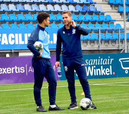Twee voetbaltrainers op het veld bij FC Den Bosch